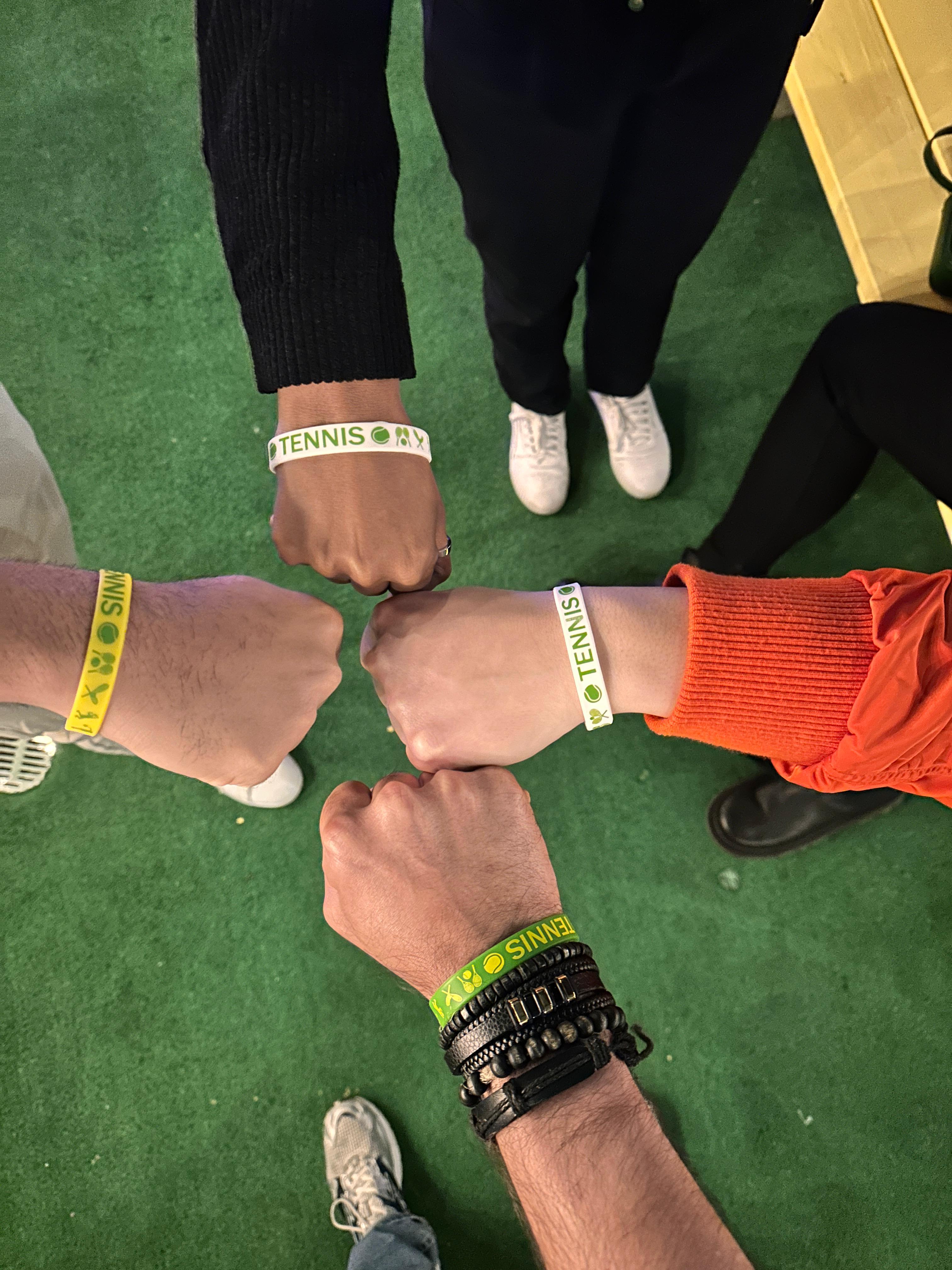 Players wearing tournament wristbands in a circle